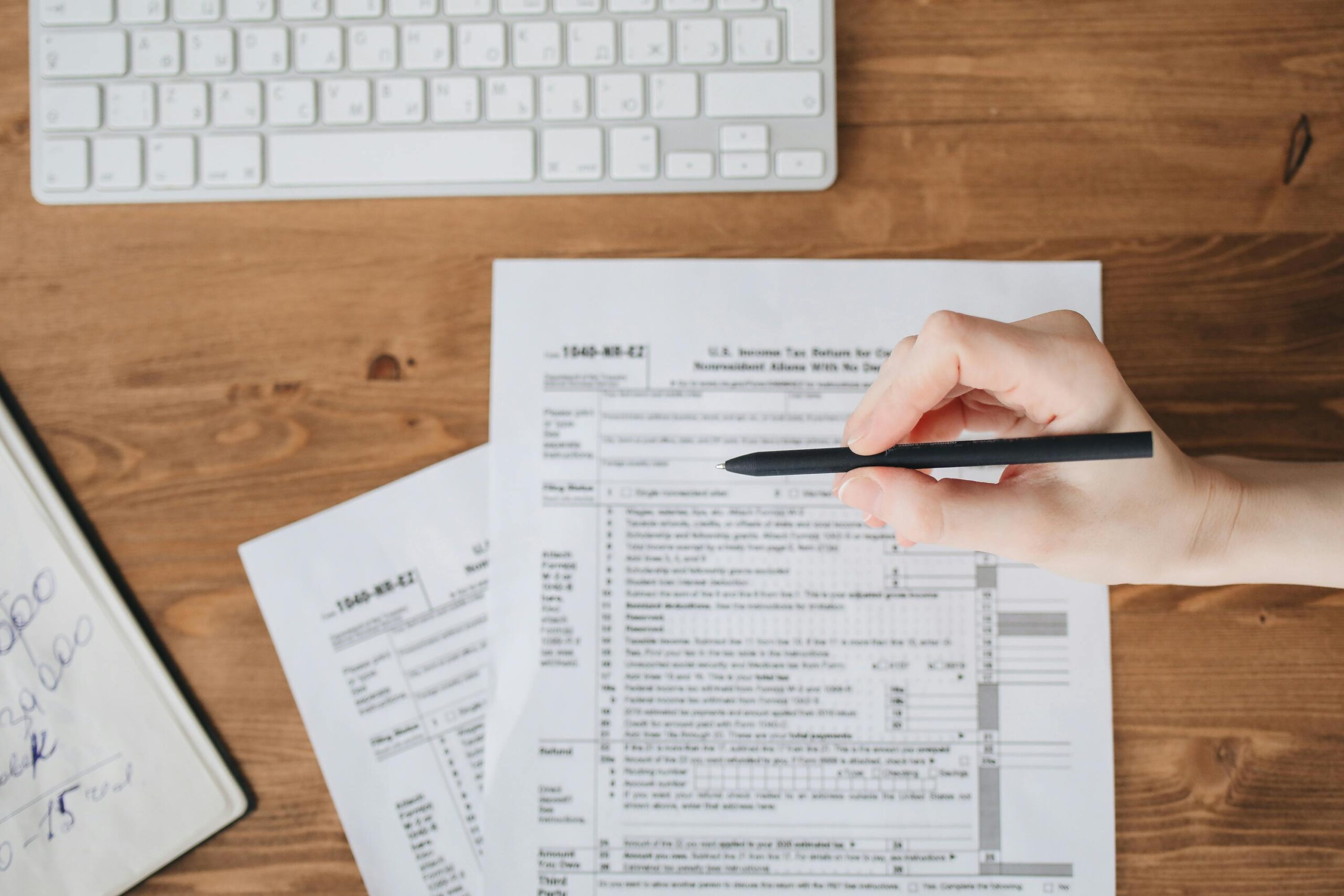 Open notebook with a checklist and a coffee mug on a wooden desk